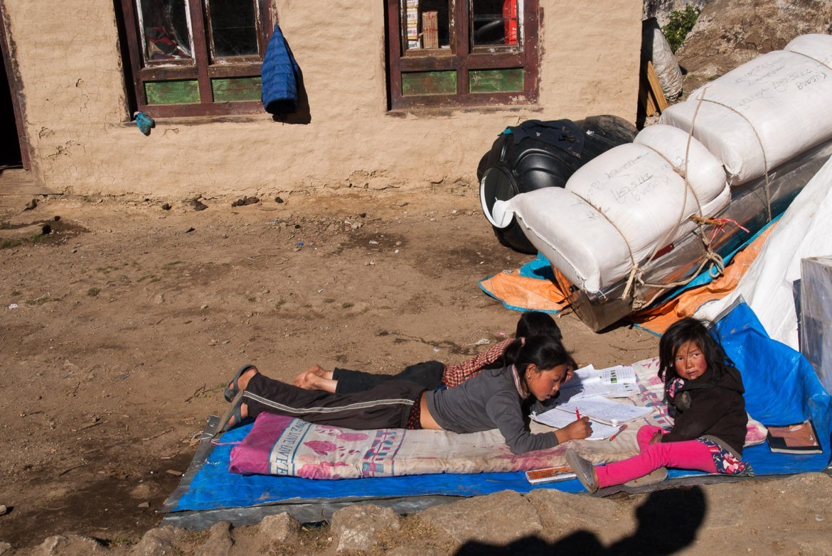 Dzieciaki w ergonomicznych pozycjach rozwiązują zadania domowe