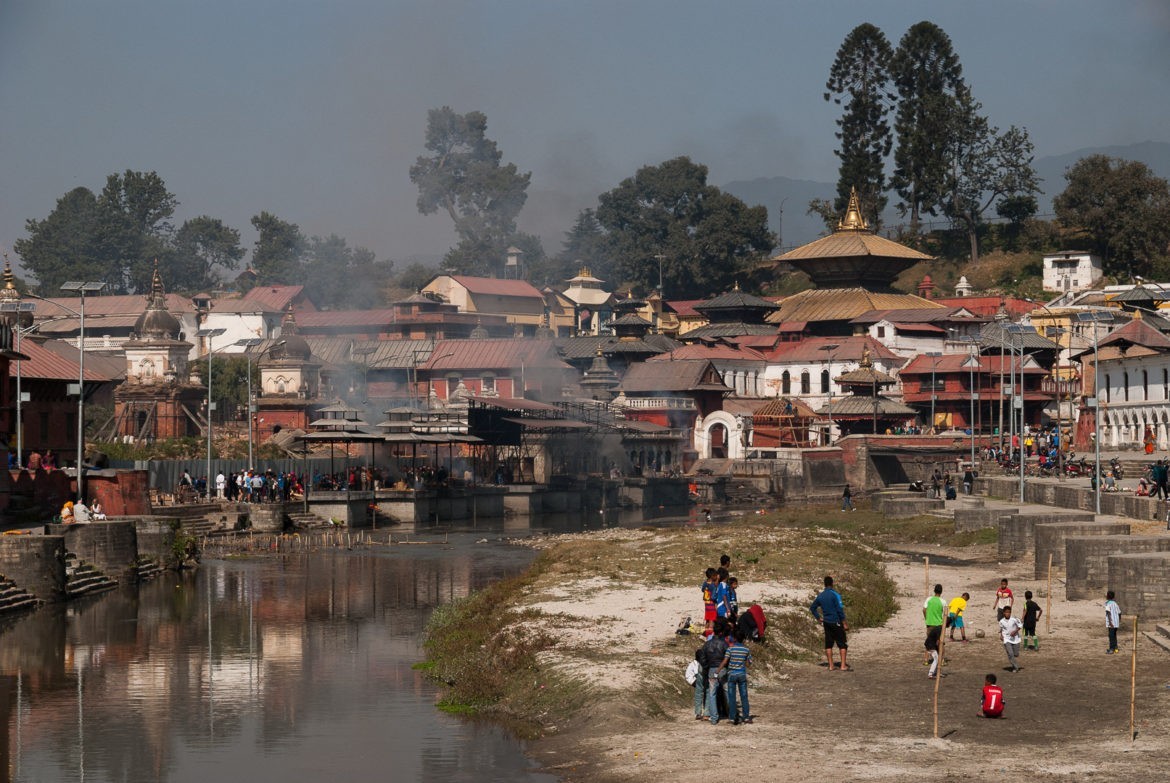 Chłopcy grają w piłkę, a kilkadziesiąt metrów dalej palone są zwłoki