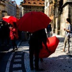 Czerwone parasole przed zegarem astronomicznym