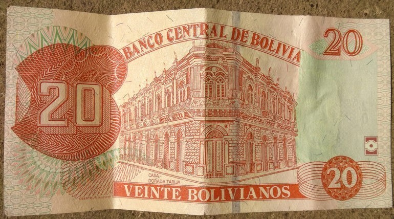 Dwadzieścia boliwijskich pieniążków z budynkiem powyżej