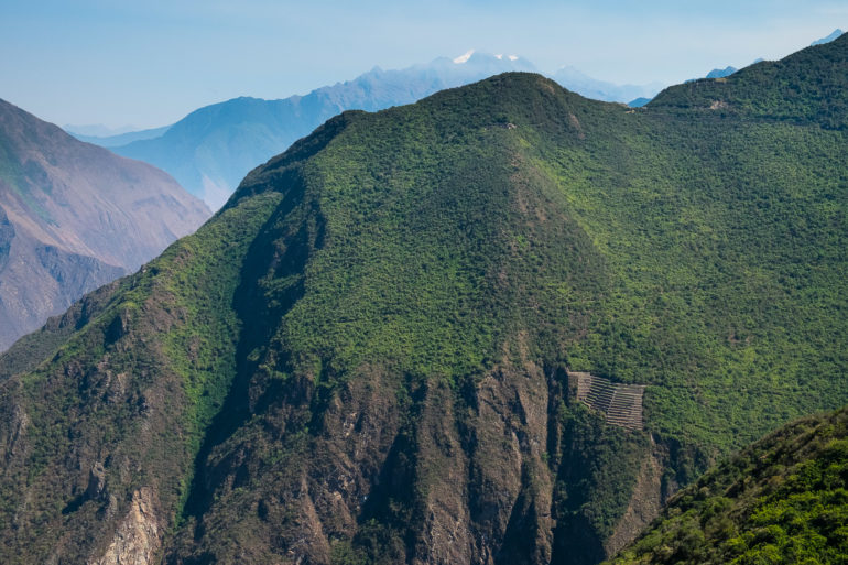 Niewyraźny widok na Choquequirao, w dole tarasy, a w tym siodełku na górze jest główny plac inkaskich zabudowań